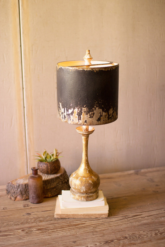 table lamp with round wooden base and black and gold metal shade
