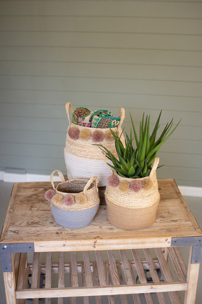 set of three seagrass and cotton folding baskets with pom poms